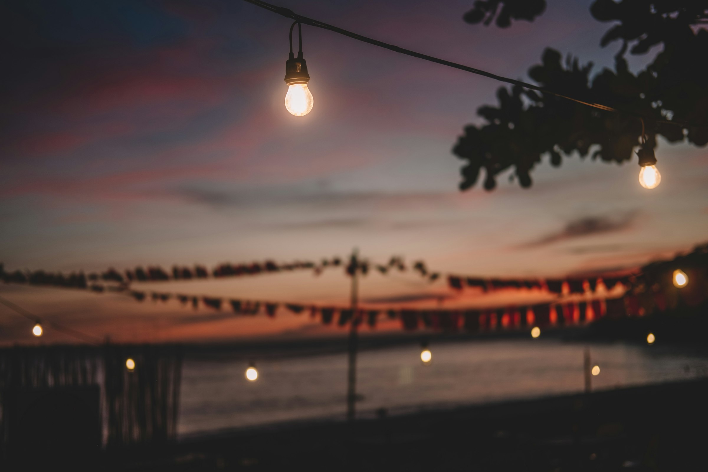 String lights over the water at dusk