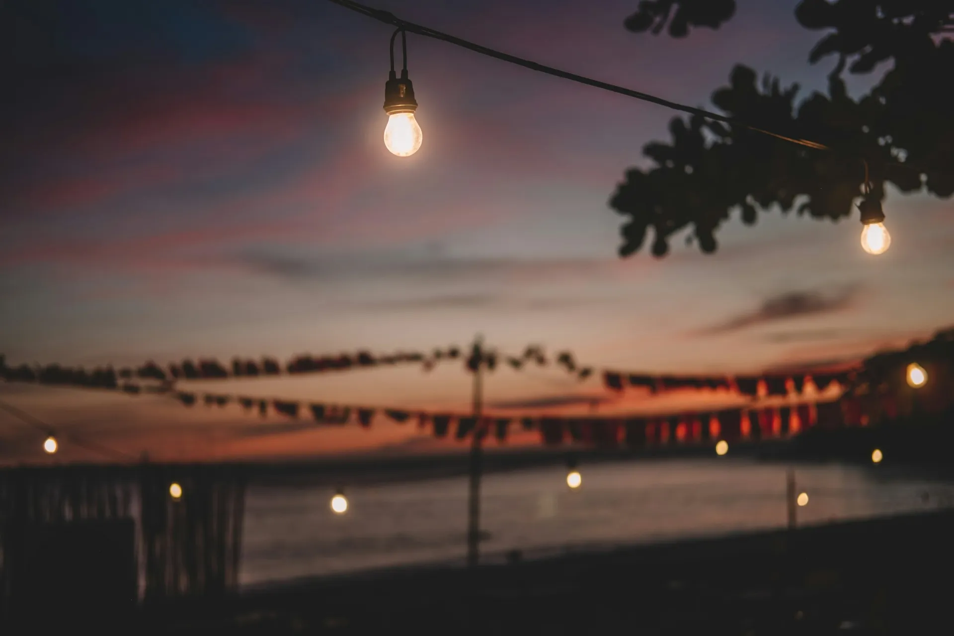Guirlandes lumineuses au-dessus de l’eau, au crépuscule