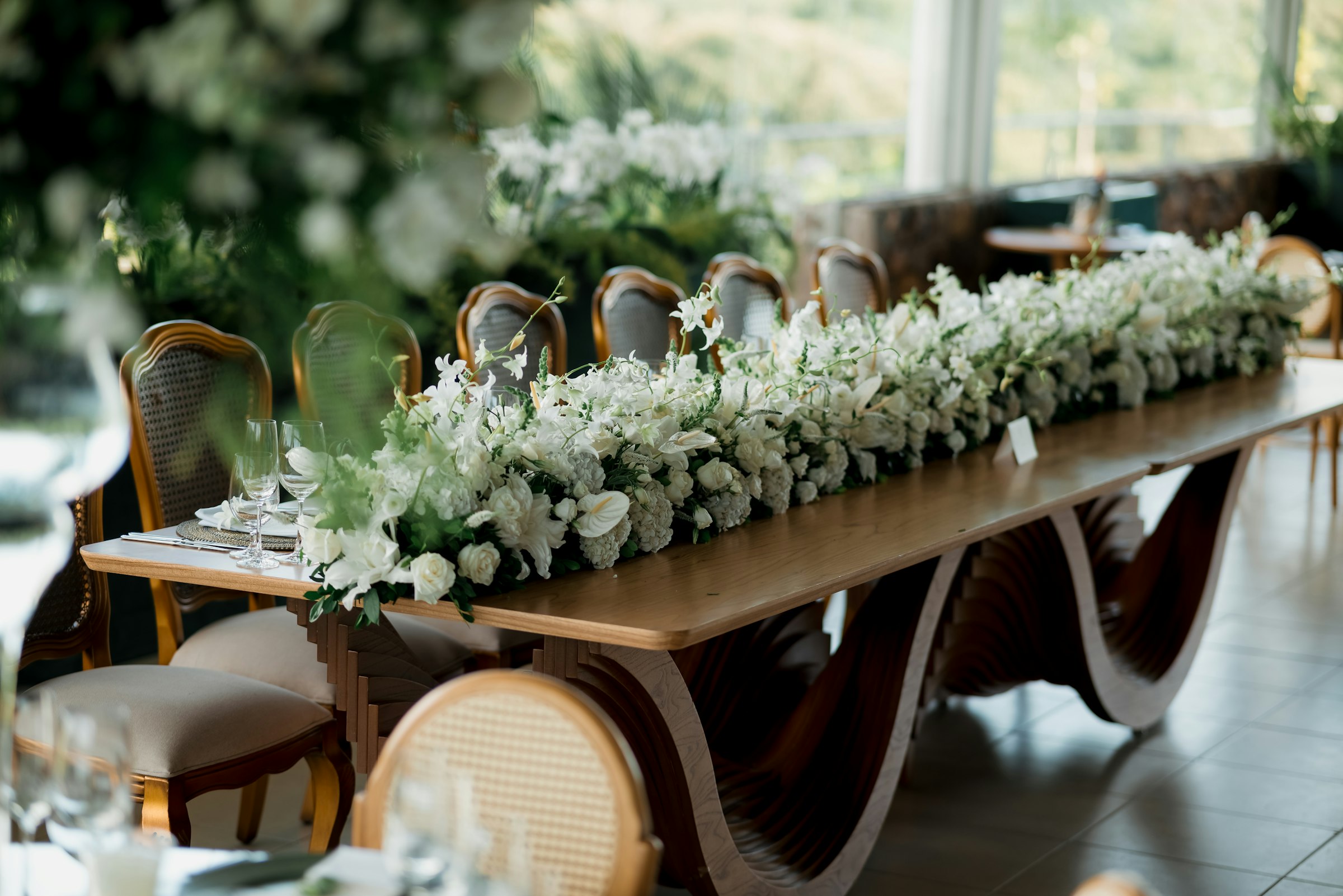 A long reception table lined with white flowers